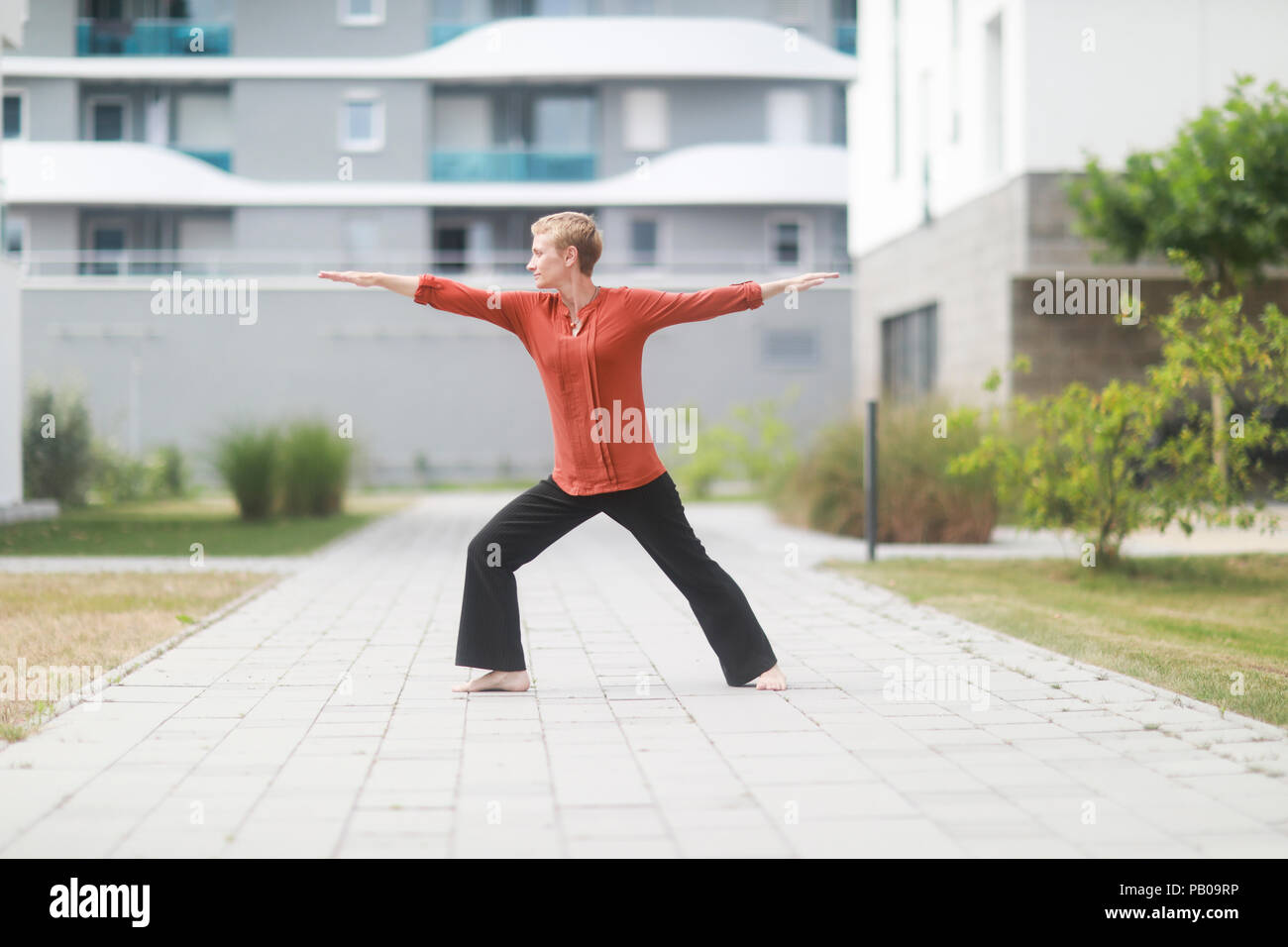 Donna in piedi fuori fare yoga warrior pongono Foto Stock
