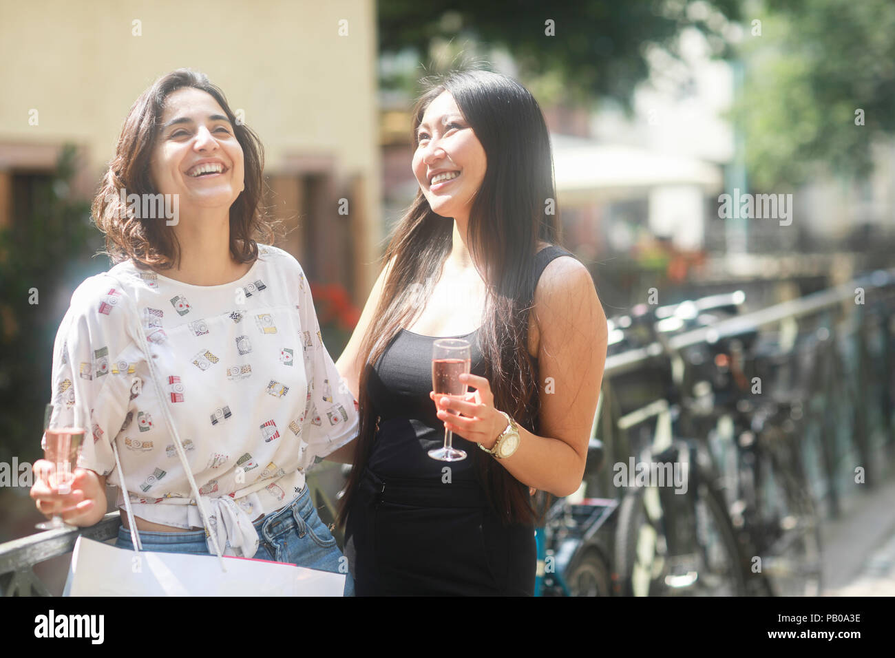 Due donne gustando un drink dopo lo shopping Foto Stock