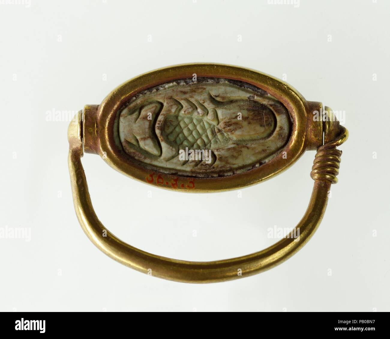 Anello di Hatnefer. Dimensioni: Anello: H. 2.1 cm (13/16 in.); W. 2,9 cm (1 1/8 in.); Cowroid: L. 2.1 cm (13/16 in.); W. (con frontalino) 2,4 cm (15/16 in.); Th. (Con frontalino) 0,7 cm (1/4 in.). Dynasty: Dynasty 18, presto. Regno: regno di Thutmosi II-inizio comune di regnare. Data: ca. 1492-1473 A.C. In aggiunta al suo cuore eccezionali scarabeo (36.3.2), Hatnefer fu sepolto con due piccoli scarabei (36.3.5, .6), e due set di cowroids in anelli girevoli (36.3.3, .4). Questo anello è stato trovato sul dito mignolo di Hatnefer la mano sinistra. Esso ha una scorpion inscritto sulla sua base. Museo: Metropolitan Museum of Art di New Yo Foto Stock