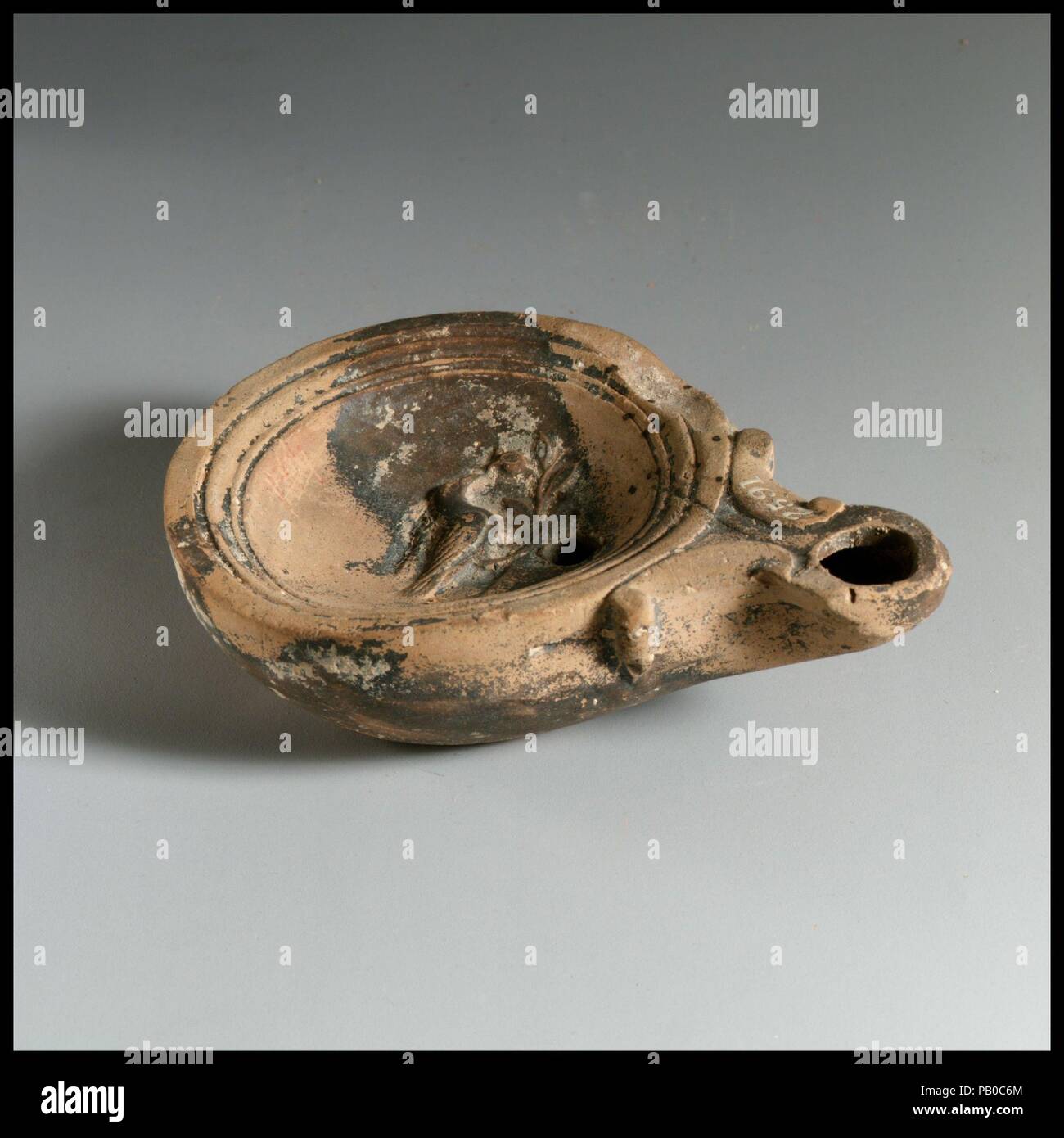 Olio di terracotta con lampada. Cultura: romana, cipriota. Dimensioni: complessivo: 1 1/16 x 3 5/8 in. (2,7 x 9,2 cm). Data: 1° secolo a.c.-1st secolo D.C.. Museo: Metropolitan Museum of Art di New York, Stati Uniti d'America. Foto Stock Olio di terracotta con lampada. Cultura: romana, cipriota. Dimensioni: complessivo: 1 1/16 x 3 5/8 in. (2,7 x 9,2 cm). Data: 1° secolo a.c.-1st secolo D.C.. Museo: Metropolitan Museum of Art di New York, Stati Uniti d'America. Foto Stock