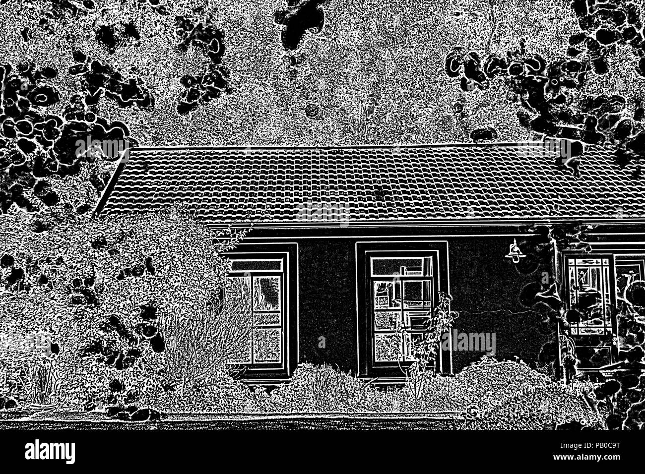 Bella casa con un sacco di vegetazione con il nero e il bianco del filtro Foto Stock