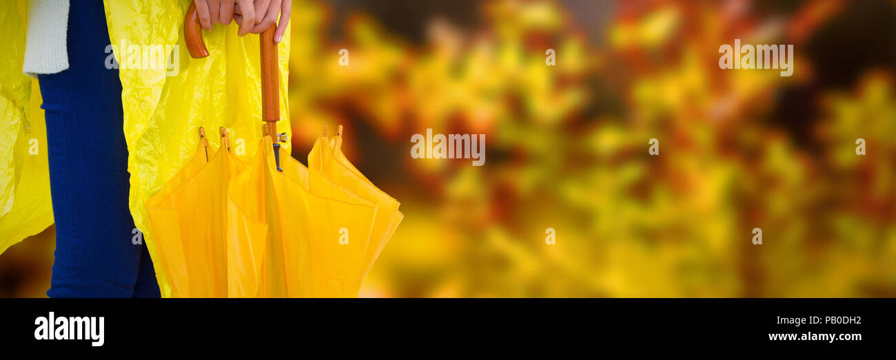 Immagine composita della donna in giallo impermeabile con ombrello Foto Stock