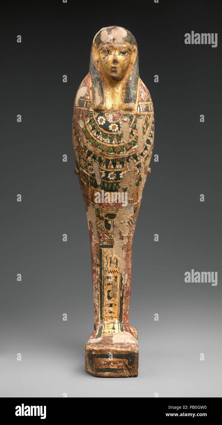 Statuetta funeraria Teshnefer denominazione. Dimensioni: statuetta: H. 29,5 × W. 7.2 × D. 6.5 cm (11 5/8 × 2 13/16 × 2 9/16 in.). Data: 332-30 BC. Questo mummiform figura assomiglia a rappresentazioni dell'uomo-guidato Imsety, uno dei quattro figli di Horus. Il modo di decorazione, con faccia dorato, rosso Sindone e stravaganti collare floreali, si trova in alcuni esempi tolemaica del dio funerari come 12.182.37b, così come nelle grandi Ptah-Sokar-Osiride figure come 21.9.1. Il nome del dio qui, tuttavia, è dato come Hekes, chi è sconosciuto, eventualmente incomprensibili. Ma il nome del proprietario e filiazione di un Foto Stock