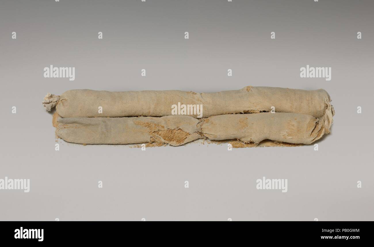 Sacco cilindrico di segatura da Tutankhamon's imbalsamazione Cache. Dimensioni: ripiegato in due rulli paralleli: L. 39,7 cm (3 7/16 in.); W. 8,7 cm (3 7/16 in.); H. 3.7 cm (1 7/16 in.) come un tubo lungo: ca. L. 75 cm (29 1/2 in.); W. 4,5 cm (1 3/4 in.); H. 3.7 cm (1 7/16 in.). Dynasty: Dynasty 18. Regno: regno di Tutankhamon. Data: ca. 1336-1327 A.C. Nel dicembre 1907 Theodore M. Davis, un ricco americano che è stato il finanziamento gli scavi nella Valle dei Re, ha scoperto un piccolo pozzo vicino alla tomba di Seti I. All'interno della fossa erano circa una dozzina di grandi sigillato imbiancate vasetti di archiviazione (09.184.1). Foto Stock