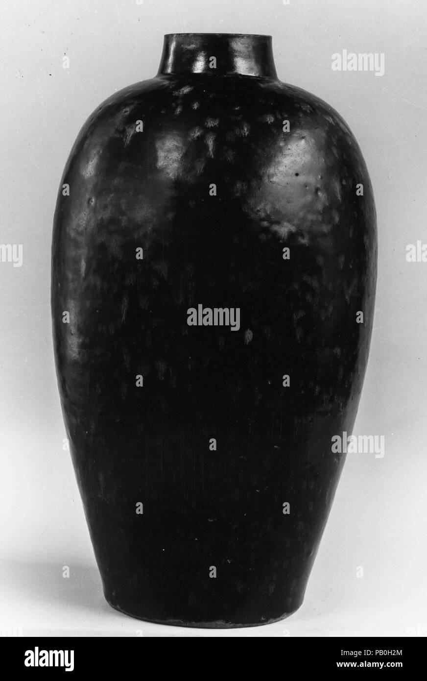 Bottiglia in forma Meiping con 'Tartaruga' Smalto. Cultura: la Cina. Dimensioni: H. 13 3/4 in. (34,9 cm); Diam. 7 1/2 in. (19,1 cm). Data: XIV secolo. Uno dei molti effetti di smalto ri-creato in Giappone e in Occidente, "tartaruga" decorazione viene creato applicando un ricche di ferro e lo slittamento di un corpo di ceramica e quindi coprendo la barbottina con un ricche di ferro e smalto. Durante la cottura lo smalto si fonde e si separa e il ferro bolle alla superficie per creare il disegno drammatico. Museo: Metropolitan Museum of Art di New York, Stati Uniti d'America. Foto Stock