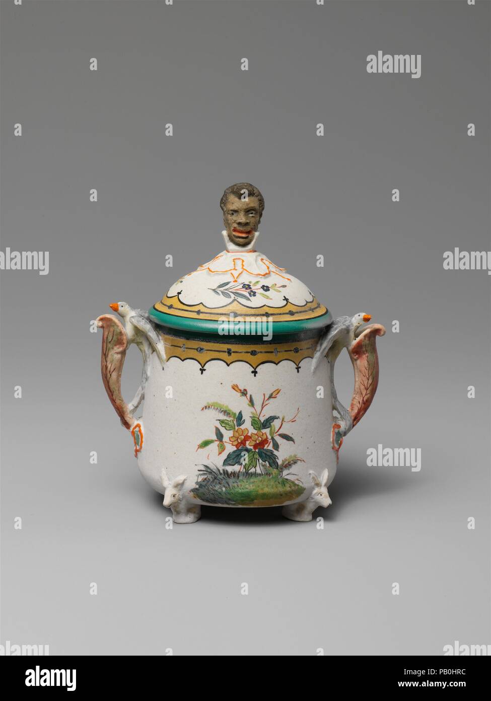 Sugar Bowl. Cultura: American. Progettista: progettato da Karl L. H. Müller (ca. 1820-1887). Dimensioni: 4 3/4 x 4 1/2 in. (12,1 x 11,4 cm). Produttore: fabbricati dalla unione di opere di porcellana (1863-ca. 1922). Data: ca. 1876. Il figurale finials--un uomo cinese sulla teiera e un africano raccoglitrice di canna da zucchero in Sugar Bowl--alludono al presunto contenuto di navi in questo eccentrico Revival rococò set da tè (69.194.7-.14). Museo: Metropolitan Museum of Art di New York, Stati Uniti d'America. Foto Stock
