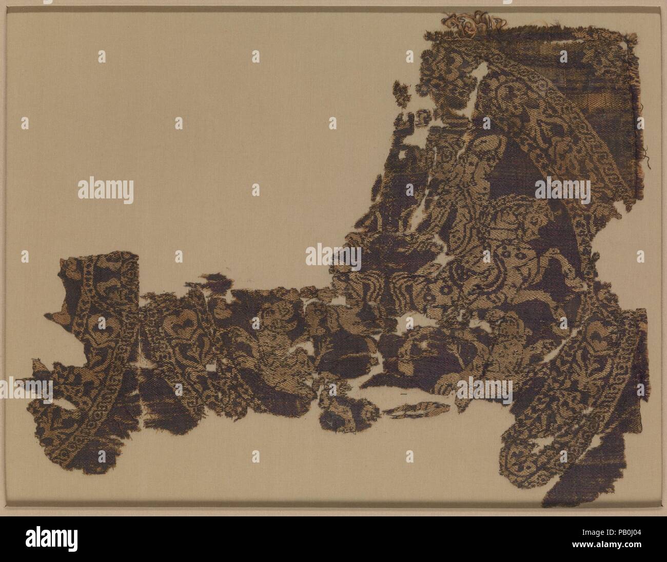 Frammento. Dimensioni: Tessile: H. 8 1/4 in. (21 cm) W. 11 a. (28 cm) Monte: H. 12 a. (30,5 cm) W. 14 3/4 in. (37,5 cm) D. 1 1/4 in. (3.2 cm). Data: 8. secolo. Questo frammento di seta raffigura un cacciatore montato mirando a una pantera saltando in un ovale roundel con lo scorrimento della vegetazione. I resti di un altro roundel sul lato sinistro di questo frammento di codice mostra che questo progetto sarebbe stato ripetuto molte volte su un grande pezzo di seta. Il motivo di cacciatori a cavallo con archi e frecce proviene da Sasaniane Iran ma ha fatto il suo modo in araldica bizantina, dove è stato adattato e classi Foto Stock