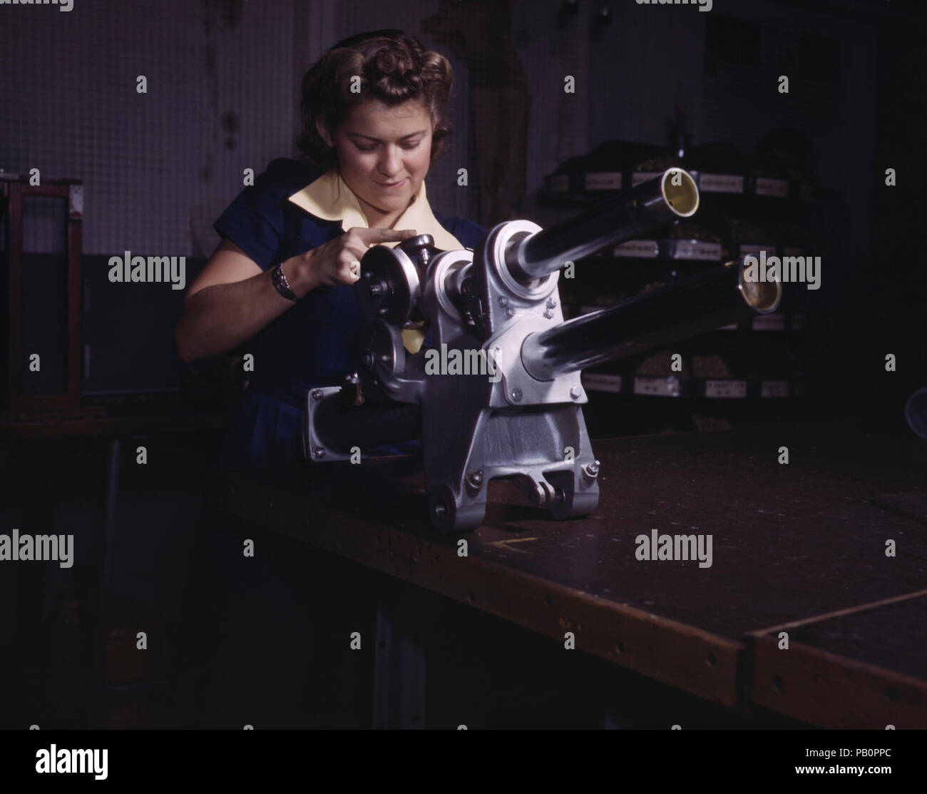 Una giovane donna dipendente di North American Aviation, Incorporated, operando sul carrello di atterraggio del meccanismo di movimentazione di una P-51 aereo da combattimento, Inglewood, Calif. Foto Stock