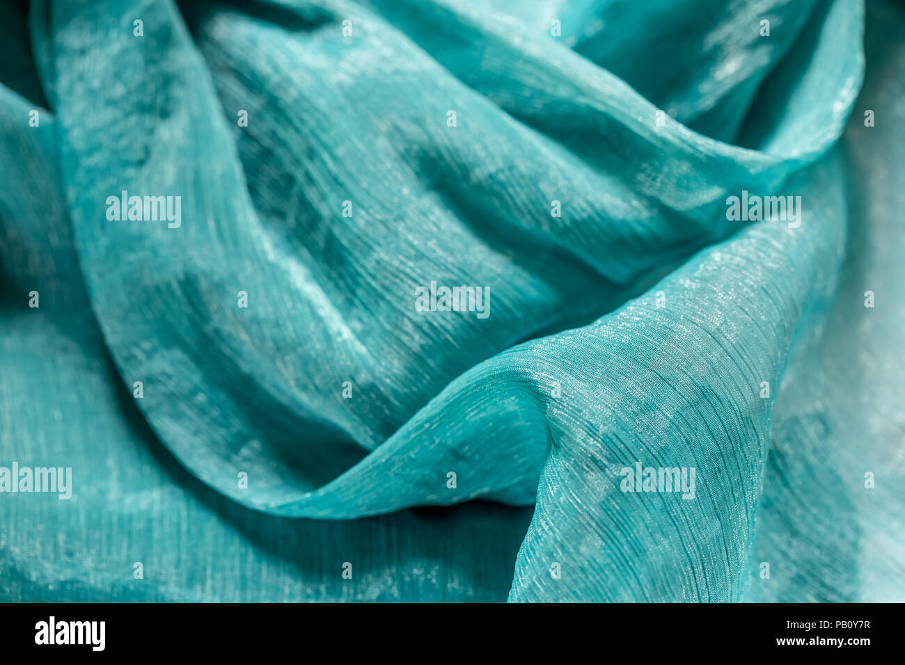 La texture del panno verde. Primo piano della ondulatorio del tessuto di seta. Abstract sullo sfondo di un lussuoso abito tessile Foto Stock