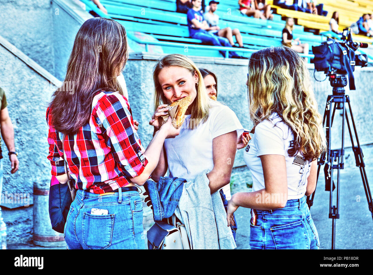 Giovani giocoso e piuttosto football americano cheerleaders femmina a Kiev Spartak stadium (Ucraina) Godetevi uno spuntino veloce tra gli uomini i giochi Foto Stock