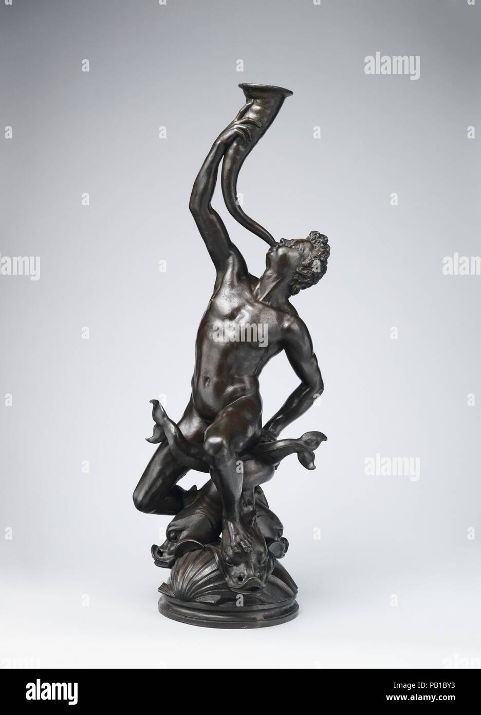 Triton. Artista: Giambologna (Netherlandish, Douai 1529-1608 Firenze). La cultura italiana, Firenze. Dimensioni: Altezza: 36 in., 53,9 lb. (91,4 cm, 24,4 kg). Data: 1560-70. Il Triton, seduto su di una base circolare formata da tre delfini con code intrecciate e teste appoggiate su tre invertiti conchiglie, originariamente serviva come una fontana la figura. Come la maggior parte dello scultore le composizioni di questo lavoro è stata pensata per essere vista da tutti i lati. Con la sua modellazione morbida e la sua vigorosa, insegue la presente il bronzo è il primo esempio di questa composizione per sopravvivere e deve essere datato all'artista Foto Stock