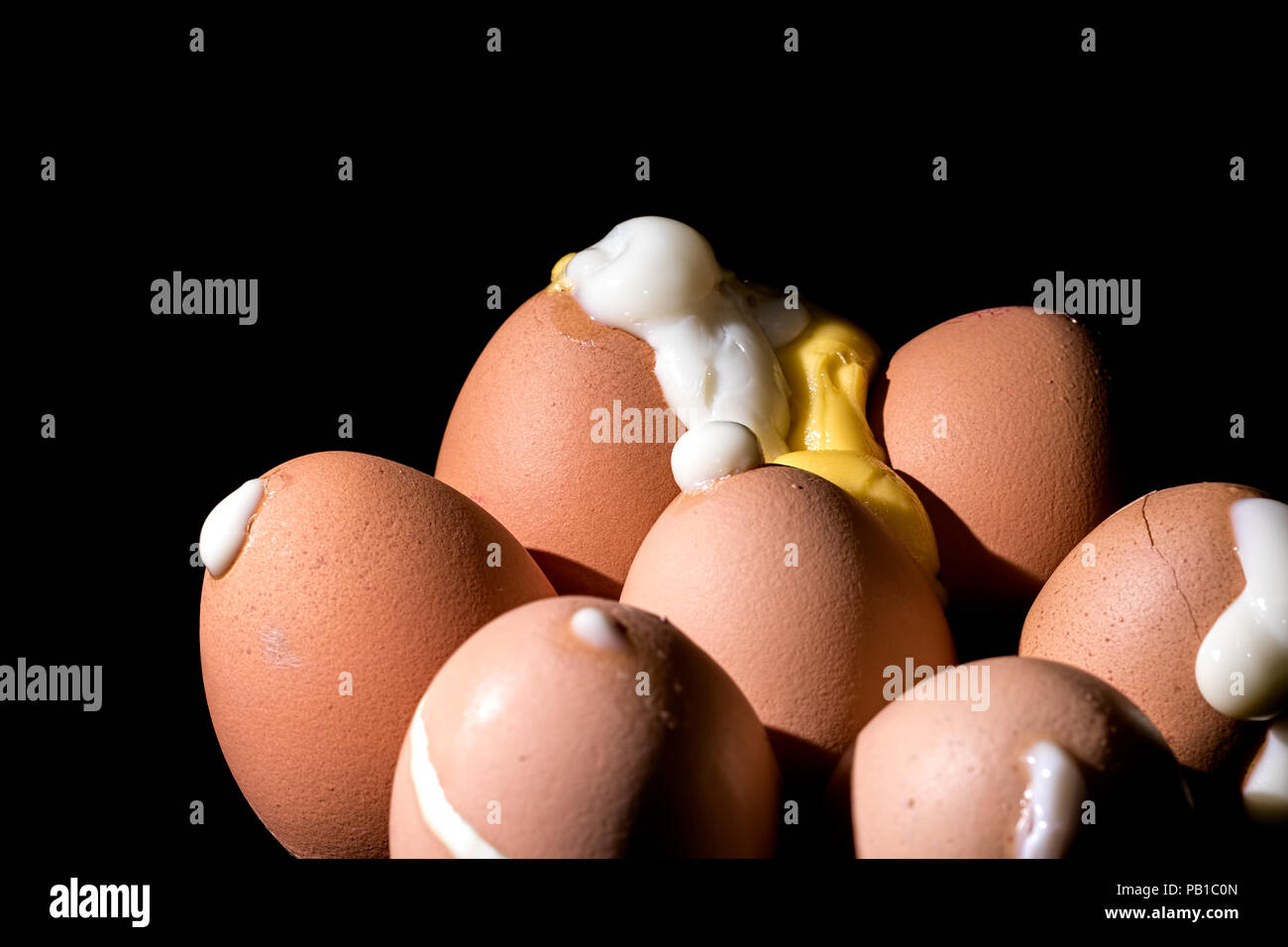 Uova sode eruttato da gusci. Sette trafitto le uova cotte. Close up è esploso gli albumi e tuorli su sfondo nero. Foto Stock