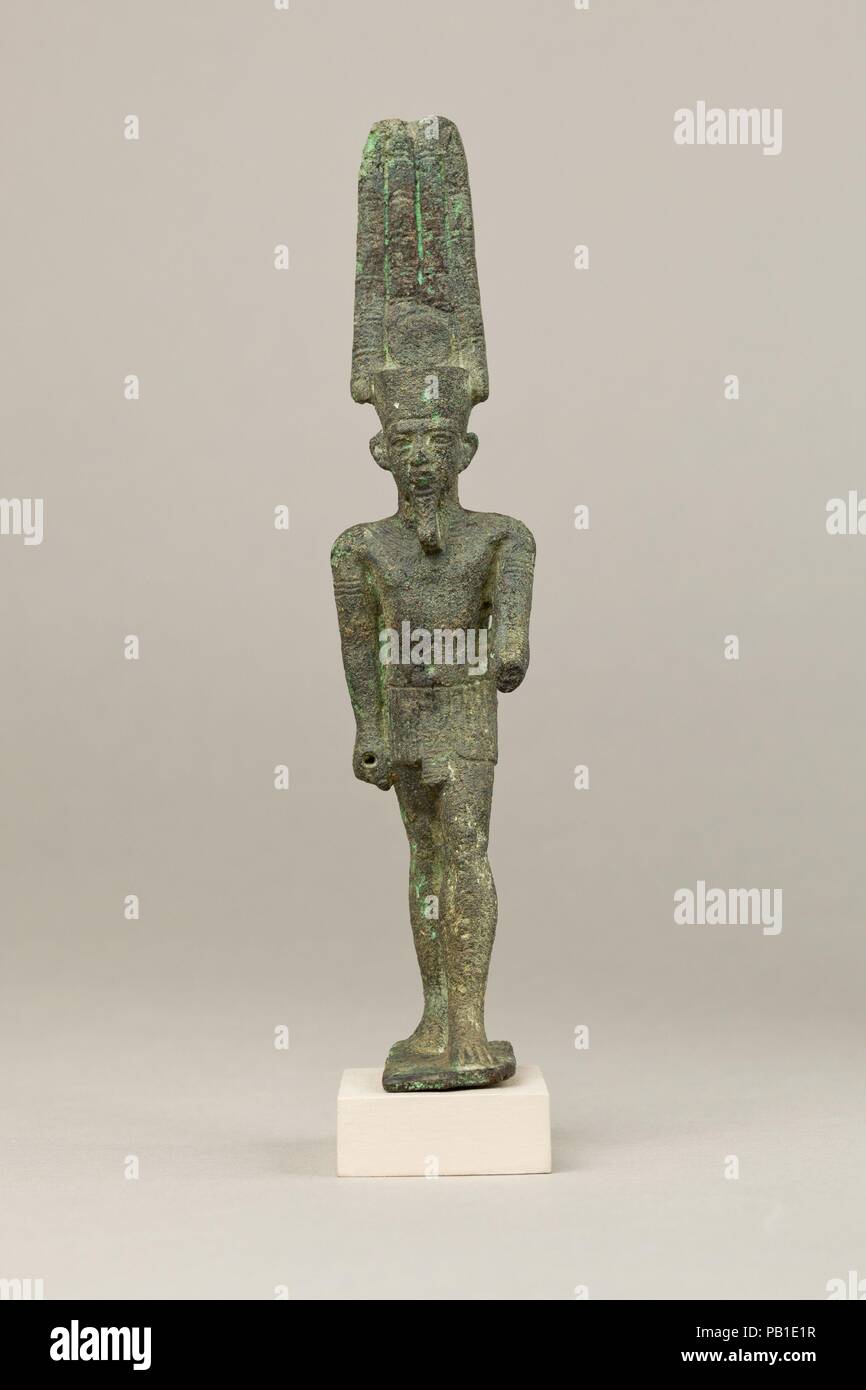 Amon. Dimensioni: H. 15,7 cm (6 3/16 in.); W. 3.3 cm (1 5/16 in.); D. 5.2 cm (2 1/16 in.). Data: 664-30 A.C.. Amon era uno di Egitto le più celebri delle divinità, adorato come un universale, cosmica di Dio e spesso chiamato il re degli dèi. In lega di rame è quasi invariabilmente mostrato, come qui, in forma antropomorfa indossando un kilt corto ed un alto doppia corona di piume con un disco solare, che allude al suo solare e aspetti cosmico, compresa la sua conflation con il dio sole Re. Ulteriori elaborazioni su questa statuetta includono un ampio collare e bracciali. La sua mano destra è munito di zoccolo per l'att Foto Stock