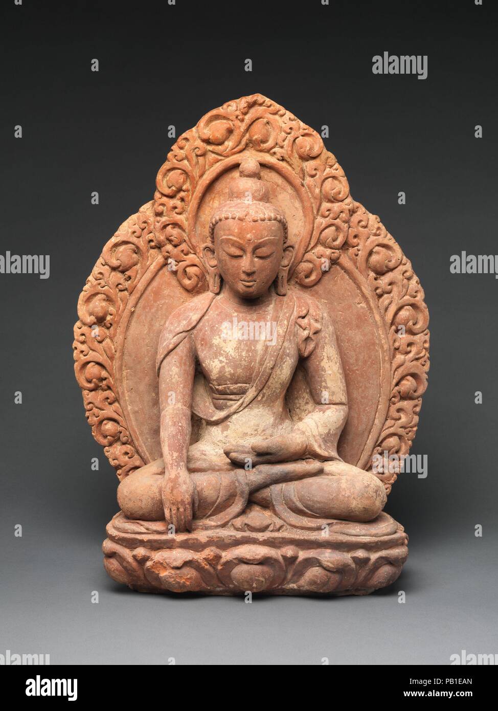 Akshobhya, il Buddha di orientali Pura Terra. Cultura: il Nepal. Dimensioni: H. 20 a. (50,8 cm); W. 14 3/4 in. (37 5 cm); D. 6 1/2 in. (16,5 cm). Data: XVI-XVII secolo. Il Buddha raggiunge la sua mano destra verso il basso in bhumisparsha mudra, segnando il momento in cui lo storico Buddha Shakyamuni chiamato la dea terra a testimoniare la sua resistenza alle forze di Mara, subito prima della sua sperimentando illuminismo. In esoterica tradizione buddista, questa iconografia è associato con Akshobhya, Buddha cosmico dell'Est. I boccioli di loto abbellendo la mandorla e il fiore aperto che serve Foto Stock