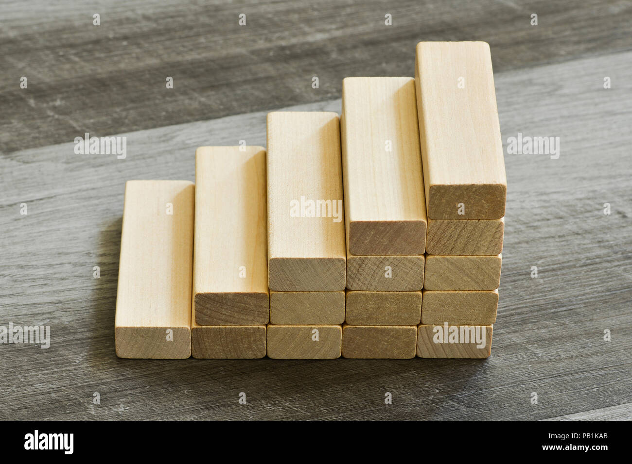 Sfida / concetto di obiettivo - Scala verso l'alto di blocchi di costruzione su grigio scuro dello sfondo in legno Foto Stock