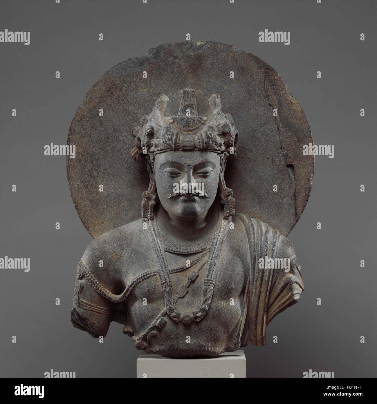 Busto di un bodhisattva Shakyamuni. Cultura: Pakistan (antica regione del Gandhara). Dimensioni: H. 18 1/4 in. (46,4 cm); W. 13 a. (33 cm); D. 6 1/2 in. (16,5 cm). Data: 3a-4a secolo. Rappresentanze di Shakyamuni prima della sua illuminazione come un bodhisattva erano popolari in Gandhara, come sottolineano la sua alta rinascita e il potenziale per diventare un re chakravartin (universal monarch). Sembra probabile che tali immagini sono state inoltre destinato a glorificare Shakyamuni la grande partenza dal palazzo--il momento in cui egli lascia il mondo illusorio del desiderio e attaccamento a cercare lumi. Museo: Metropoli Foto Stock