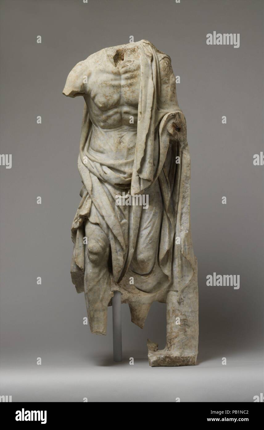 Statua in marmo di un vecchio pescatore. Cultura: Romano. Dimensioni: H. 42 a. (106,7 cm). Data: 1° o 2° secolo D.C.. Copia di una statua greca della fine del III secolo A.C. Gli effetti di un duro lavoro e di età sono potentemente reso in questa rappresentazione. Una più completa replica nella Roma conserva la testa e un cestino di pesce sul braccio sinistro, indicante che la si chinò la figura deve essere un pescatore. Poiché il suo manto voluminoso sembra poco adatto al lavoro, egli è probabilmente a capo per un festival, come è la statua di un'anziana donna che trasportano i polli e un cesto di frutta che si trova nelle vicinanze. Durante la Hellen Foto Stock