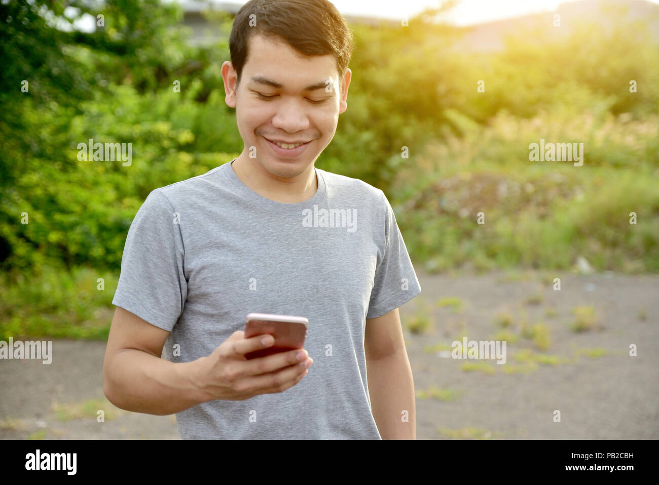 Uomo con smartphone e sorriso,l'uomo utilizzando il telefono cellulare per il lavoro e lo shopping da internet online Foto Stock