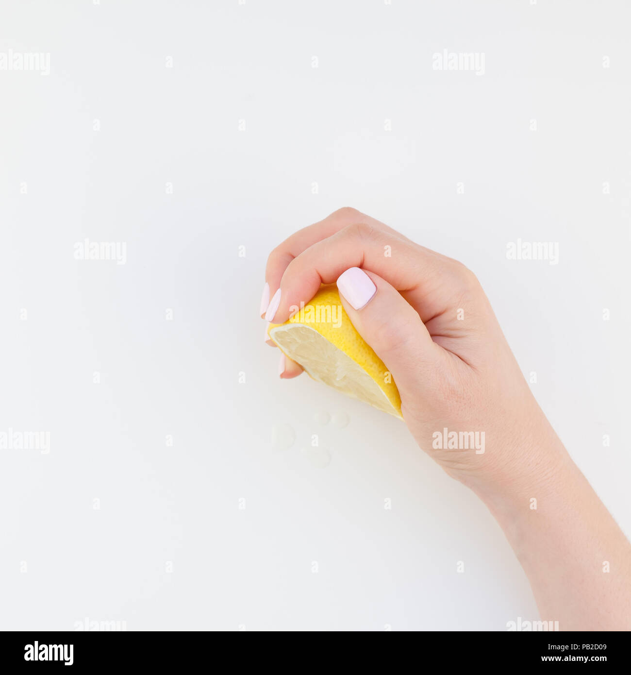 Donna con mano manicure pastello polacco tenendo un metà del limone isolati su sfondo bianco spazio copia stile minimalista. Modello quadrato per femminile Foto Stock
