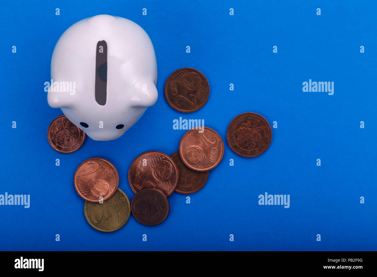 Salvadanaio con monete su uno sfondo colorato di close-up. Il concetto di risparmio e di accumulare denaro Foto Stock