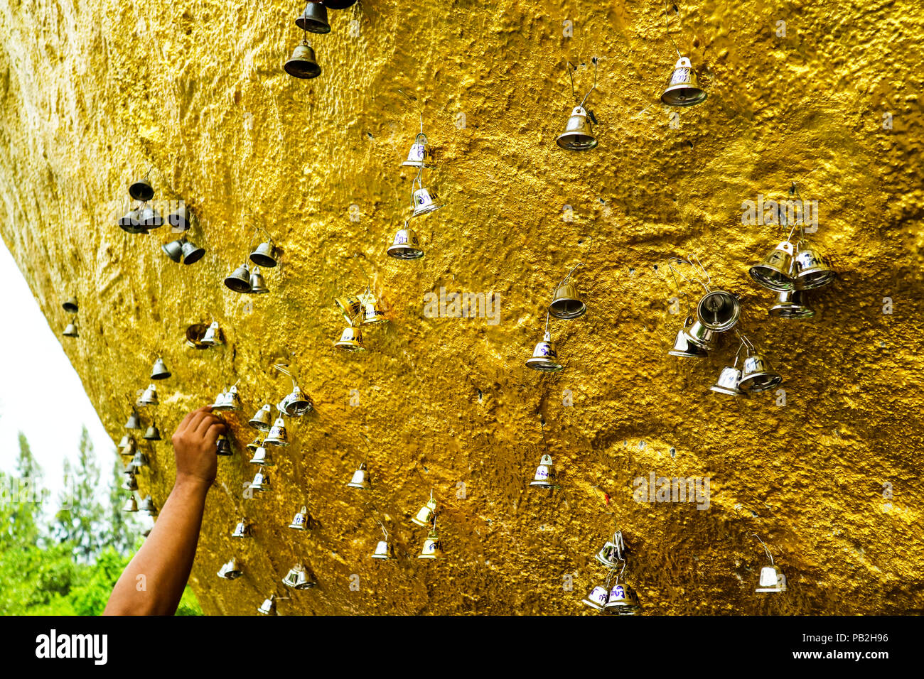 Oro e argento bell appendere su titan gold pietra, concezione spirituale, bell significato si può sentire il suono da lontano Foto Stock