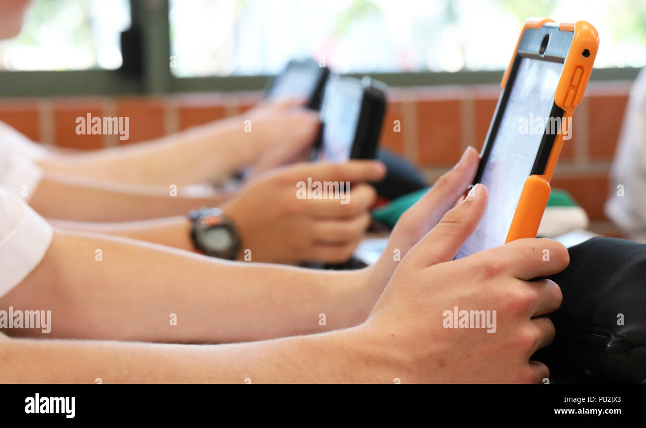 Alta scuola gli studenti che lavorano su utilizzando un ipad tablet stile elettronico del dispositivo calcolatore. pedagogia moderna insegnamento e apprendimento in istruzione istruzione Foto Stock