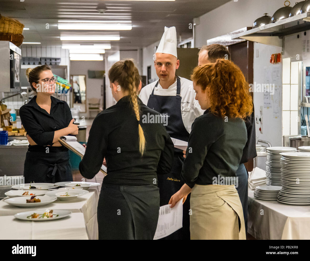 Cucina dell'Hotel Lenkerhof, Lenk, Svizzera. Stefan Lünse, il capo chef del Lenkerhof, spiega al personale del servizio ogni sera prima di cena quali piatti sono disponibili per la selezione nel ristorante gourmet Spettacolo Foto Stock