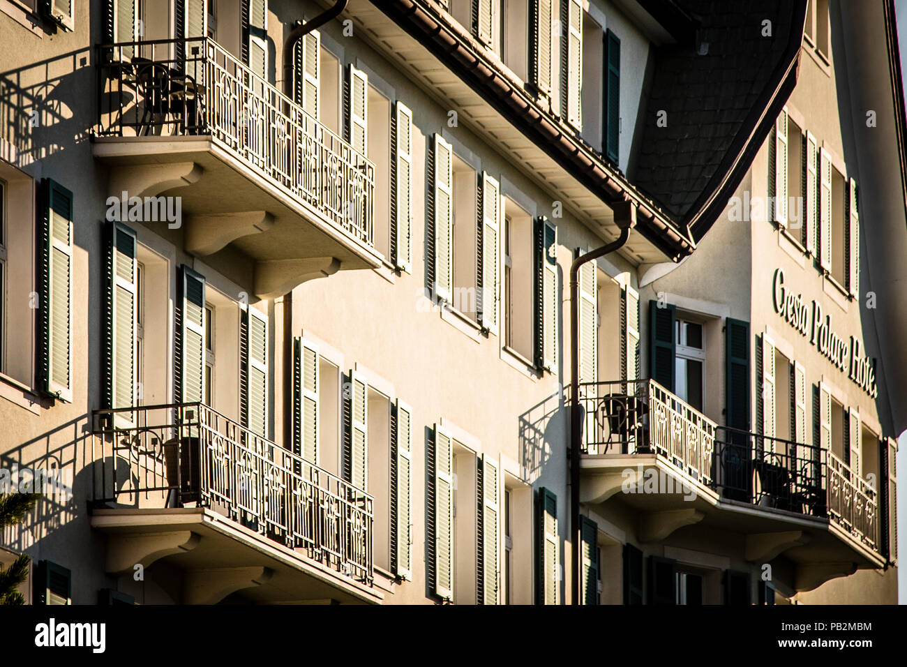 Hotel Cresta Palace, Celerina, Svizzera. Dalla strada, la façade facciata del palazzo di Cresta, progettato dall'architetto Jost-Franz Huwyler-Boller, è appena visibile dietro gli alti alberi del parco Foto Stock