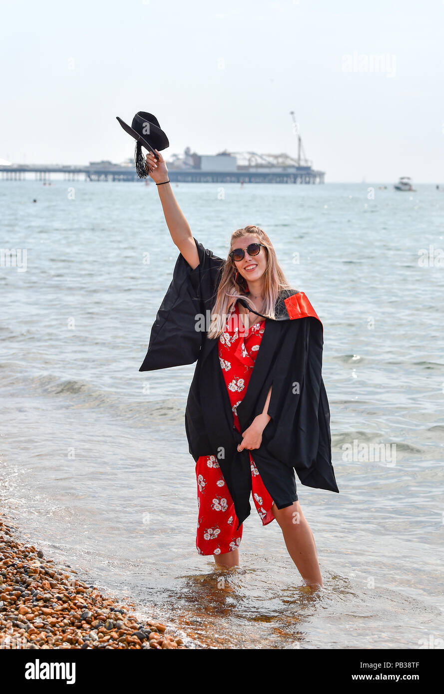 Brighton Regno Unito 26 luglio 2018 - Melissa Jensen non si raffredda con una pagaia in mare sulla spiaggia di Brighton dopo essersi laureato presso la Sussex University come l'ondata di caldo condizioni continuano sulla costa sud di oggi dovrebbe essere il giorno più caldo dell'anno finora in alcune parti della Gran Bretagna Credito: Simon Dack/Alamy Live News Foto Stock