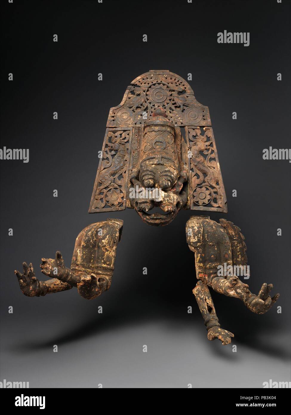 Narasimha, Vishnu's Man-Lion Avatar. Cultura: il Sud dell India, nello Stato del Tamil Nadu, probabilmente Thanjavur distretto. Dimensioni: H. (con supporto) 47 1/2 in. (120.7 cm); W. 40 a. (101,6 cm ); D. 20 a. (50,8 cm). Data: ca. 1700-1750. In questa maschera di straordinario ensemble, la testa coronata di Narasimha è accompagnata da un corpo vestito con sei bracci articolati. La fase in presenza dell'attore che indossava questo ensemble, completamente assorbito nel ruolo del feroce man-lion avatar, sarebbe stata eccezionale quando visto sul fiocamente illuminate stadio durante la notte le prestazioni. La vernice su questa maschera è stata aggiornata ogni anno Foto Stock