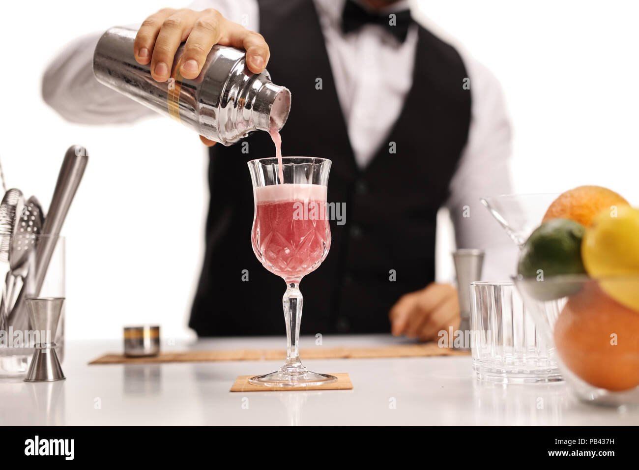 Barista versando la sua firma di cocktail in un vetro isolato su sfondo bianco Foto Stock