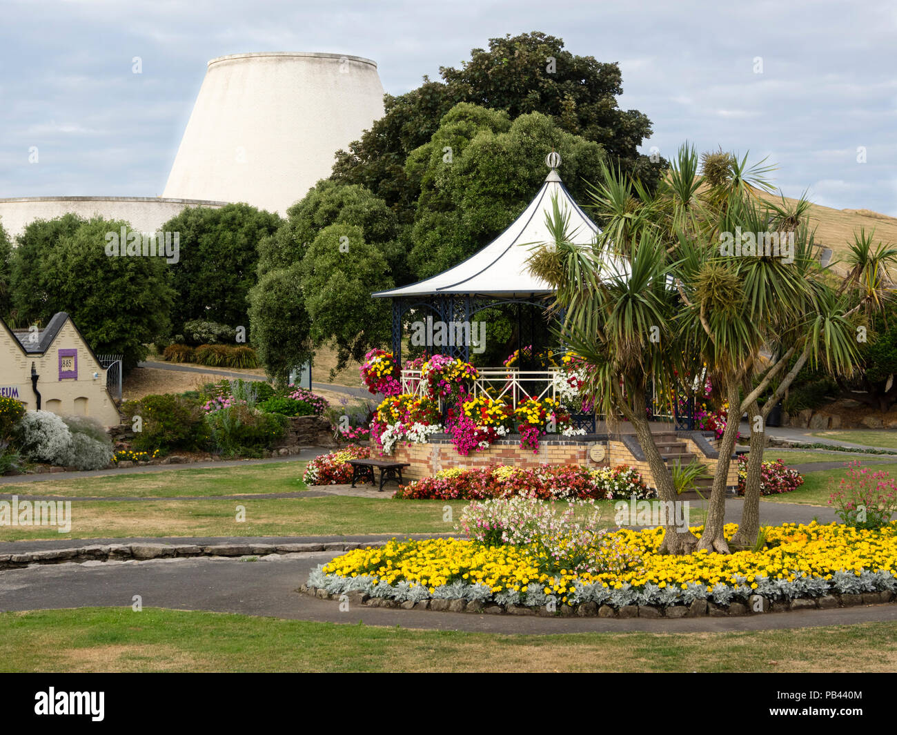 Estate fiori di biancheria da letto a letto e intorno al palco per spettacoli in giardini Runnymede, Ilfracombe, Devon, Regno Unito. Landmark Theater in background Foto Stock