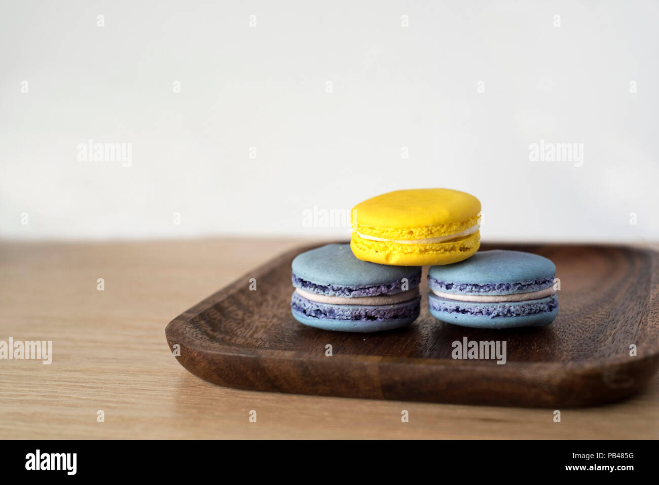 Giallo e Blu di Macaron torre sul piatto di legno Foto Stock