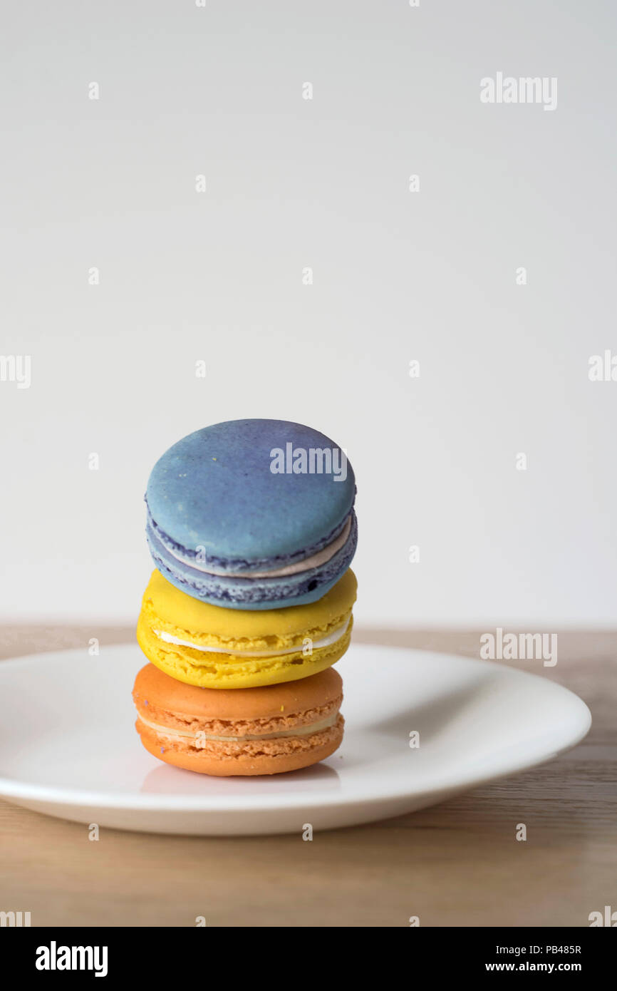 Inclinazione pila di Macarons - Francese Dessert pasticceria trattare su un piatto di portata Foto Stock