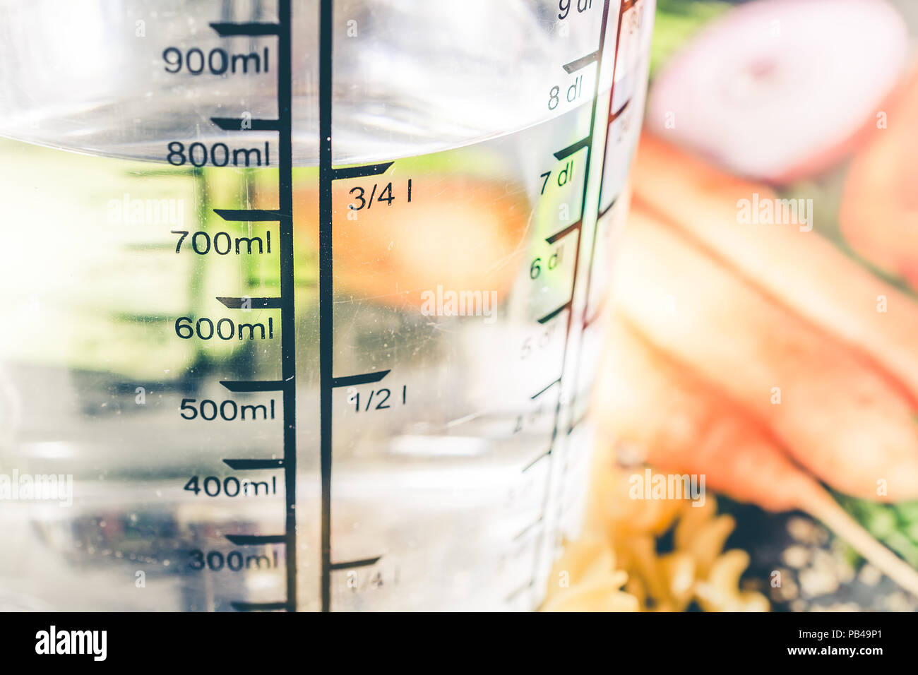 750 ml - ccm di acqua in una coppa di misurazione circondato dalle tagliatelle, cipolla, carote e spezie Foto Stock