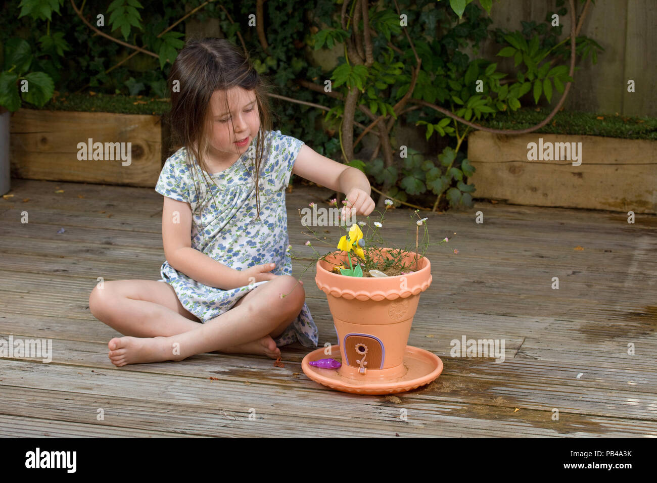 Giovane ragazza che gioca con il suo giardino di fata Foto Stock