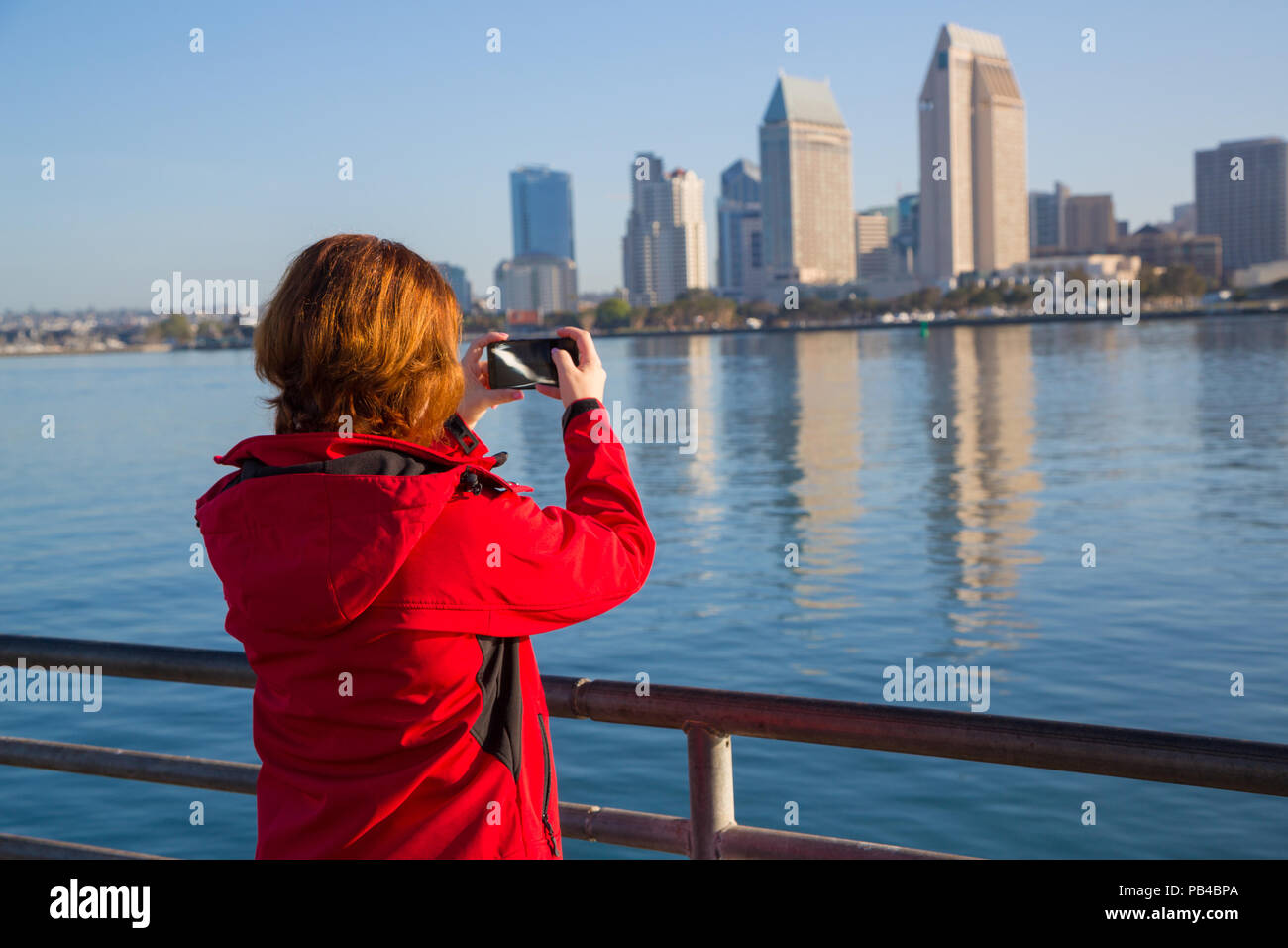 Giovane donna prende le foto utilizzando smart telefono cellulare Foto Stock