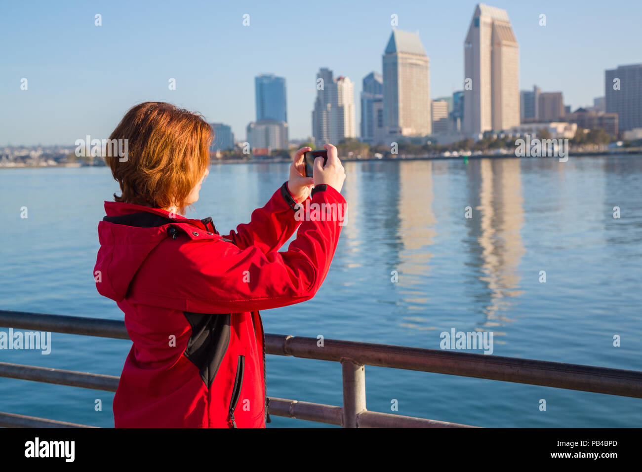 Giovane donna prende le foto utilizzando smart telefono cellulare Foto Stock