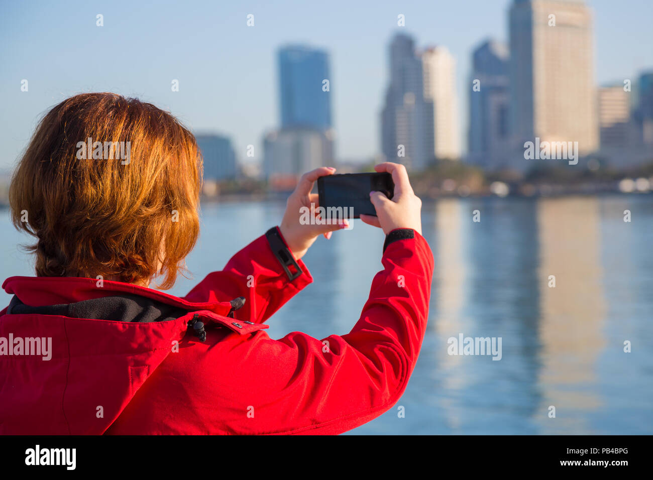 Giovane donna prende le foto utilizzando smart telefono cellulare Foto Stock