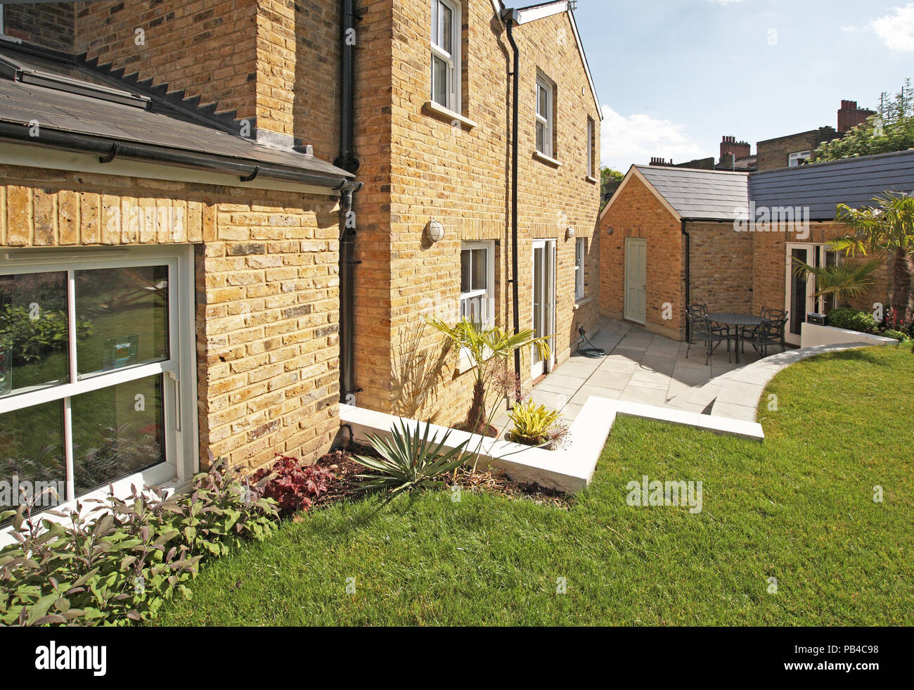 Un esteso casa vittoriana nel sud di Londra, Regno Unito, mostra nuovo,costruiti in mattoni camera giardino circondato da un giardino sfoggiato. Foto Stock