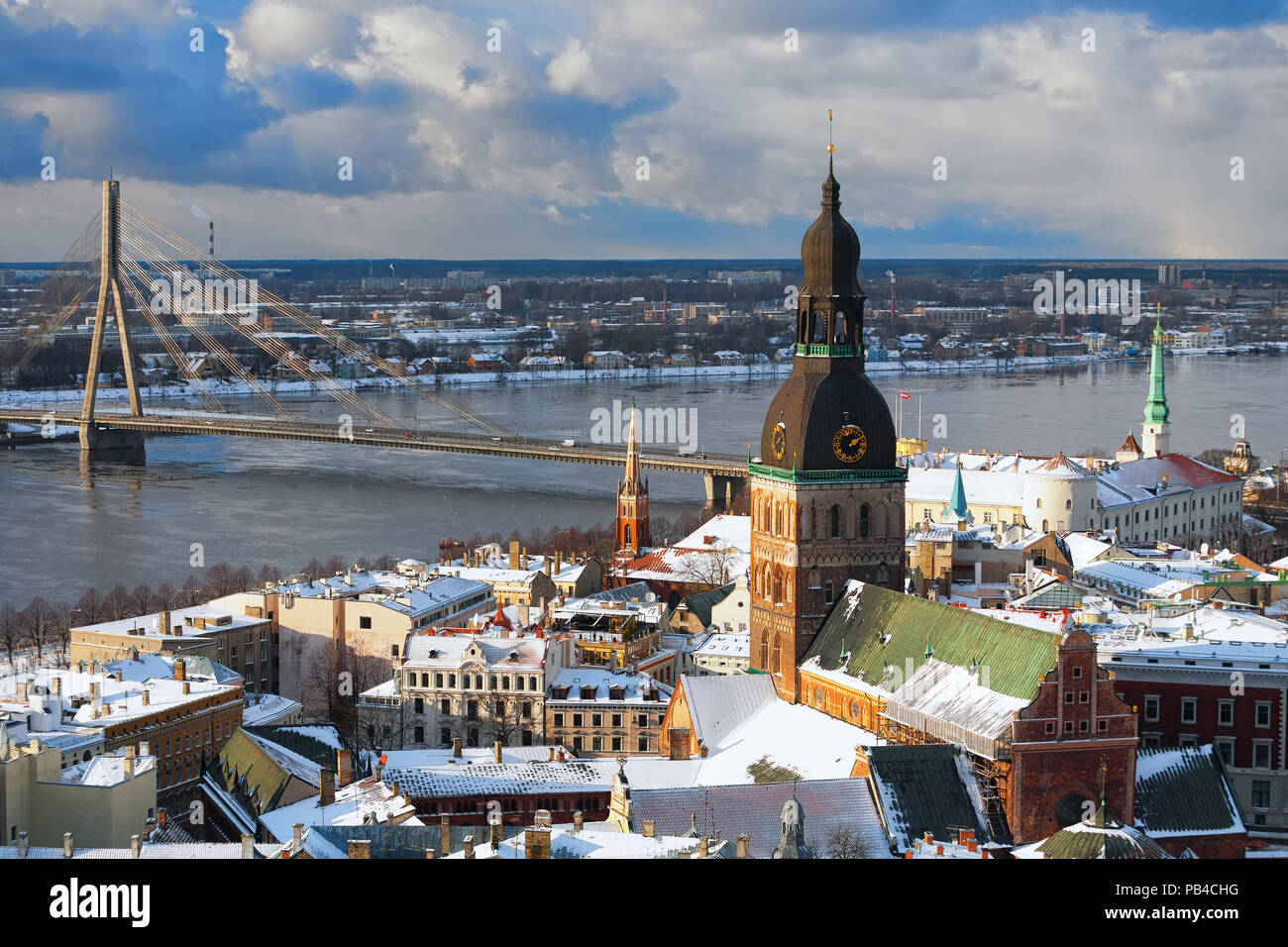 I tetti delle case e cattedrale spiers di Riga ponte sul fiume dall'aria in inverno Foto Stock