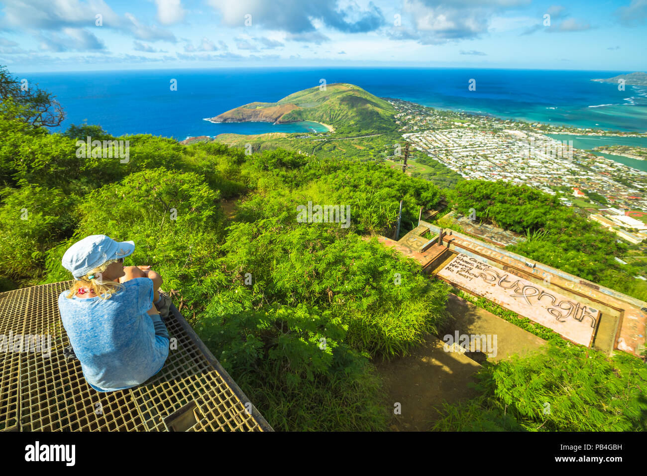 Traveler donna che guarda il panorama sulla parte superiore di Koko Head scale escursione. Vista aerea di Hanauma Bay su sfondo in Oahu Island, Hawaii, Stati Uniti. Hawaiian gite nella natura paesaggio panoramico. Foto Stock