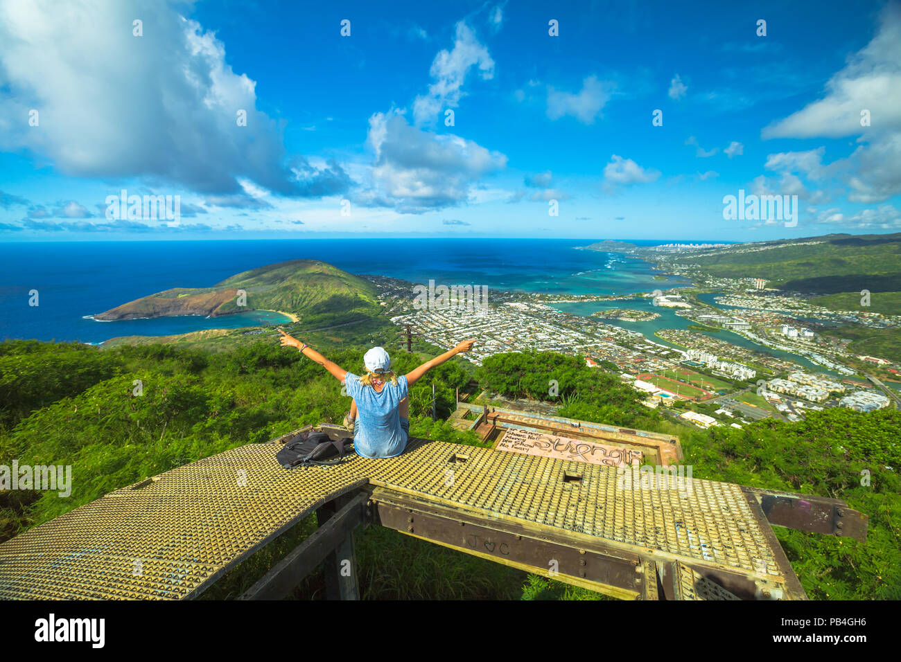 Donna felice godendo al top di Koko Head Crater trail.Vista aerea di Hanauma Bay, Diamond Head e di Honolulu e Oahu, Hawaii, Stati Uniti d'America. Hawaiian gite nella natura paesaggio panoramico.escursionista femmina con i bracci sollevati Foto Stock