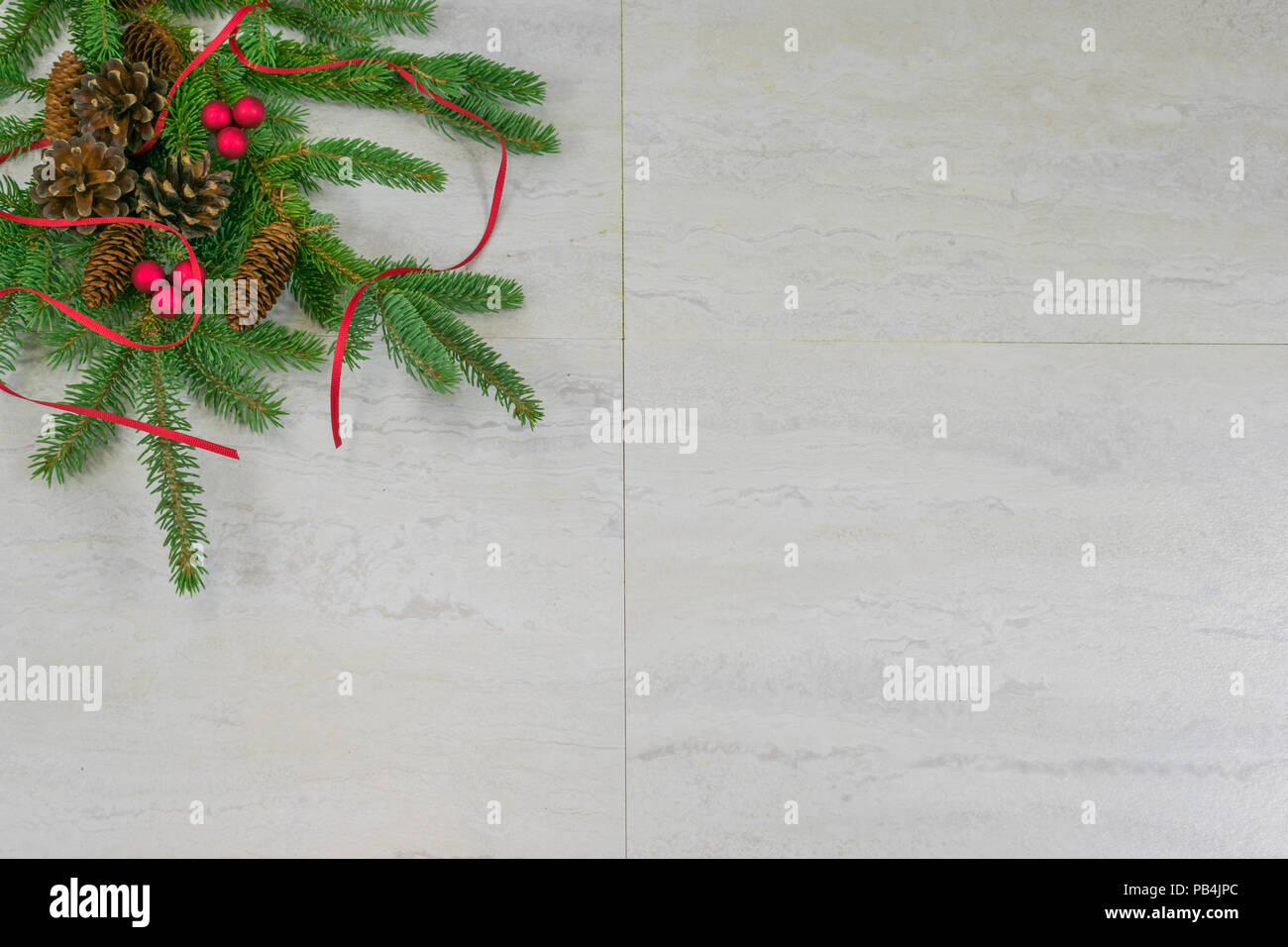 Cinque abete e tre Scotch pigne lungo con due grappoli di bacche rosse e nastro rosso su un abete fronda nell'angolo superiore destro con co Foto Stock