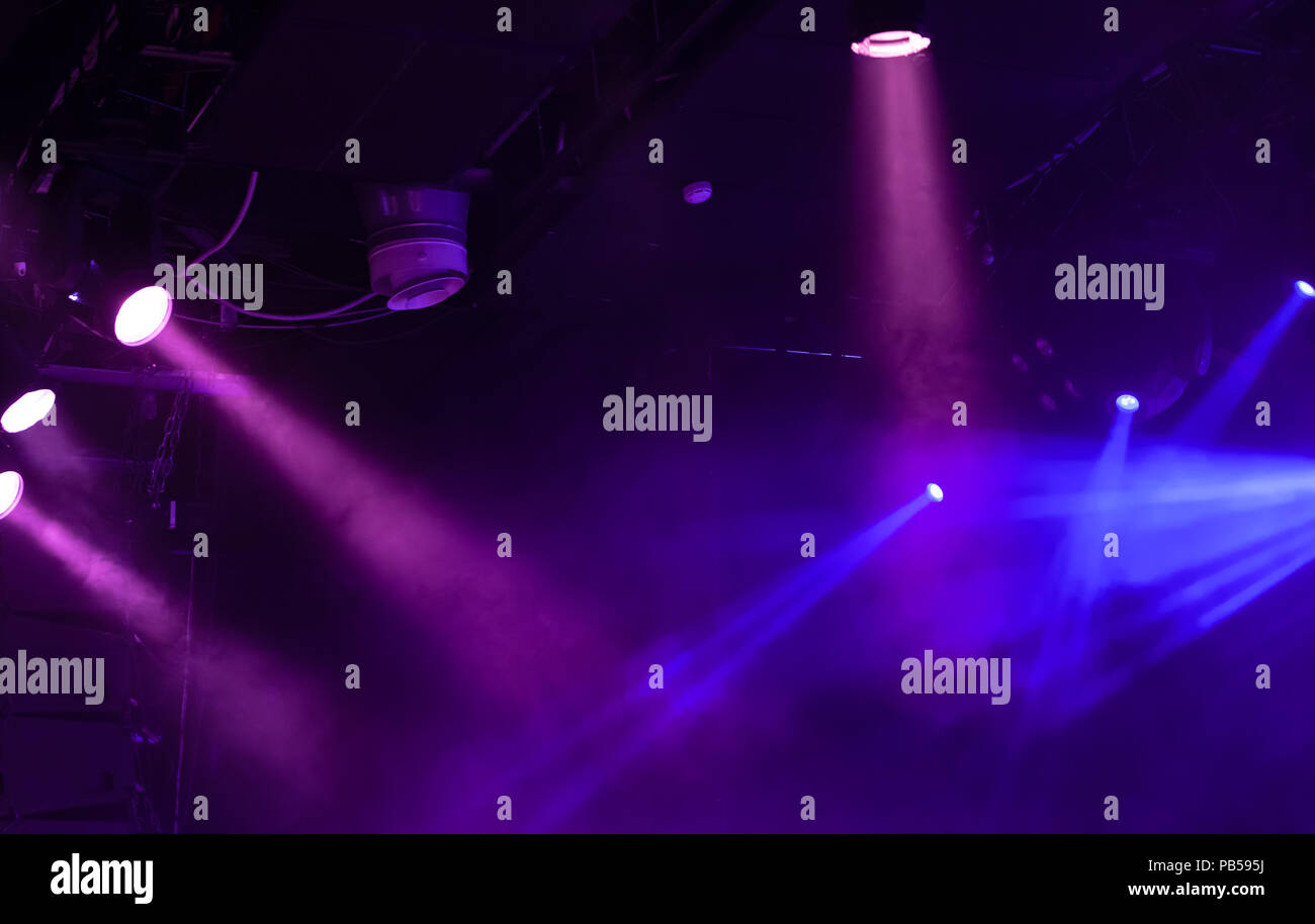 Blu e viola scenic luci con fasci di forte in fumo su sfondo scuro, stadio di moderne apparecchiature per illuminazione Foto Stock