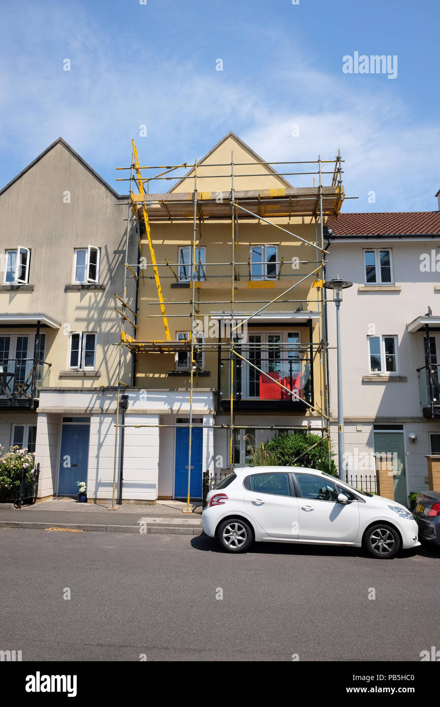 Luglio 2018 - Casa di città con un impalcatura di accesso per consentire ai costruttori per riparare il tetto Foto Stock