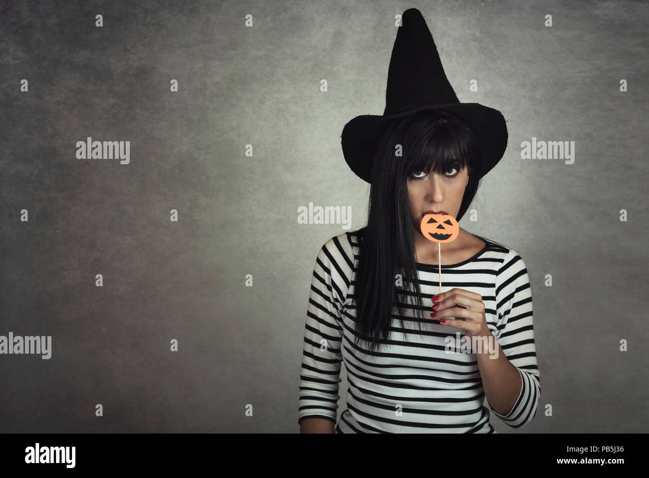 Giovane donna in possesso di una zucca di Halloween Foto Stock