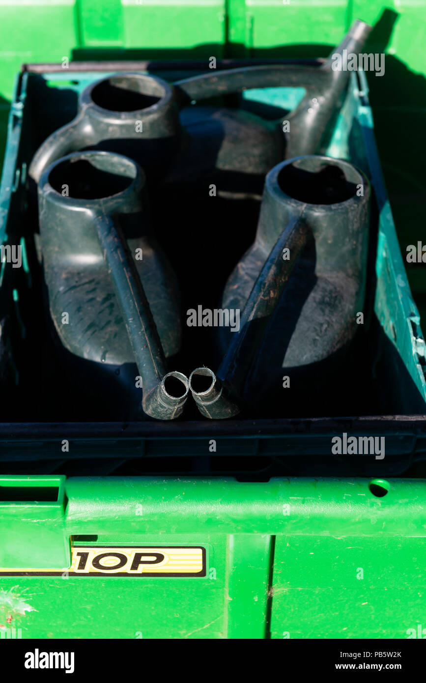 Plastica lattine di irrigazione nel retro di un John Deere rimorchio da giardino Foto Stock