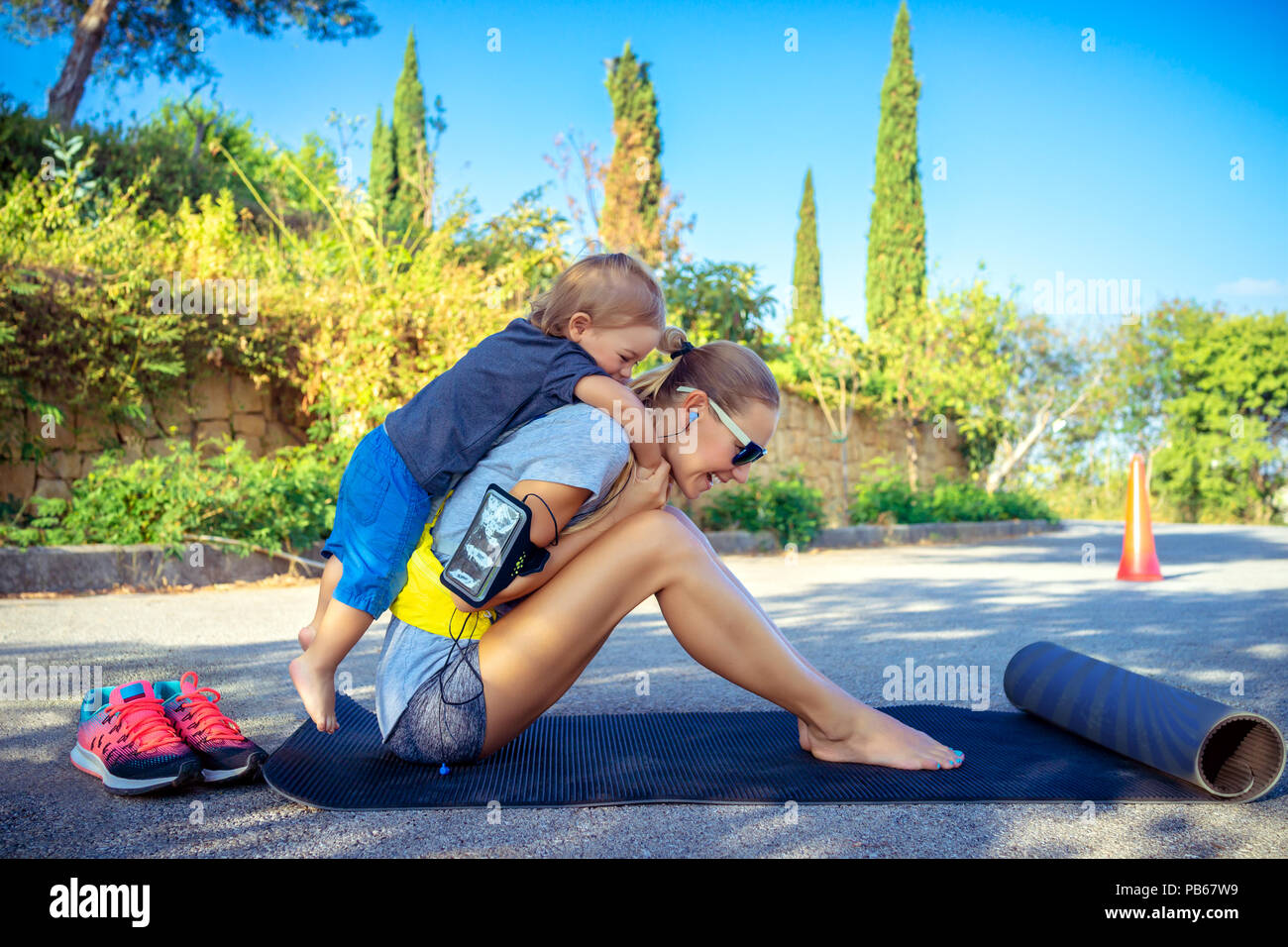 Mamma e suo figlio gioca sport giochi nel parco sulla soleggiata giornata estiva, felice infanzia attivo, buona famiglia amorevole concept Foto Stock