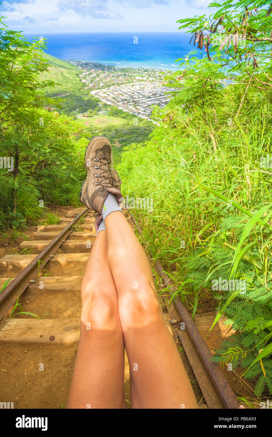 Dettagli della donna gambe con scarpe da trekking sulla scalinata di popolari escursioni hawaiano, Koko Head scale escursione. Scenario paesaggistico di Oahu Island, Hawaii, Stati Uniti. Colpo verticale. Foto Stock